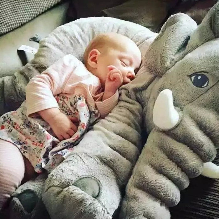 Gray elephant doll pillow with plush elephant head and tusk, baby resting
