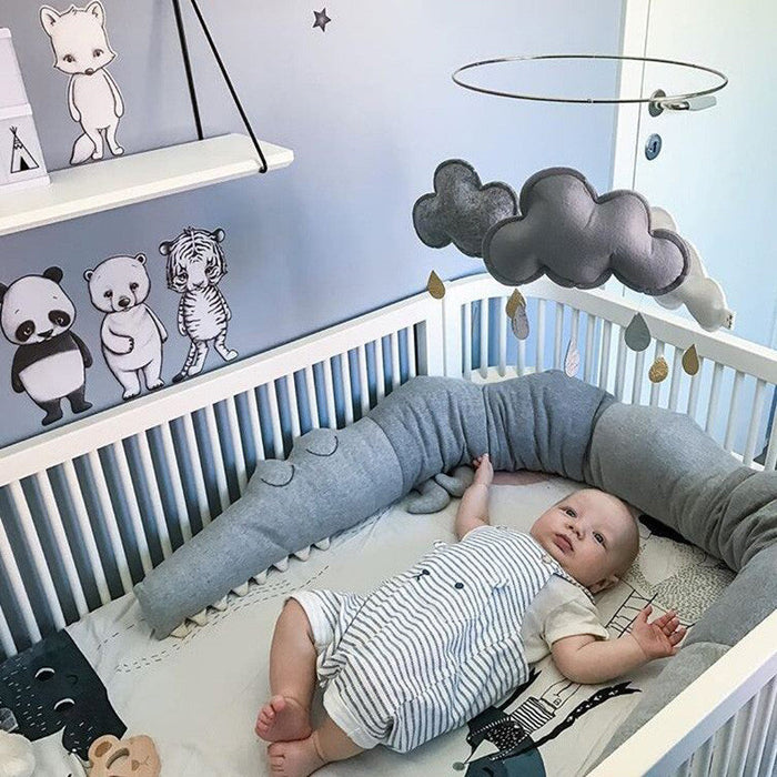 Gray crib bumper pillow with cloud-shaped topper and stitched animal rail prints