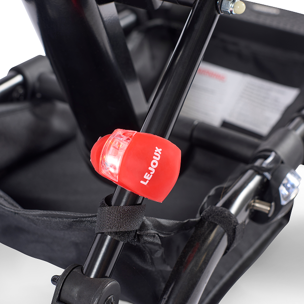 Red silicone safety light with clear lens, LEJOUX, strapped to stroller bar