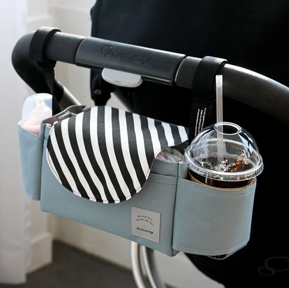 Stroller storage bag with grey fabric and striped pouch, attached to stroller handle