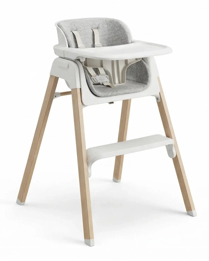 White high chair with grey fabric seat pad, white tray, and light wood legs