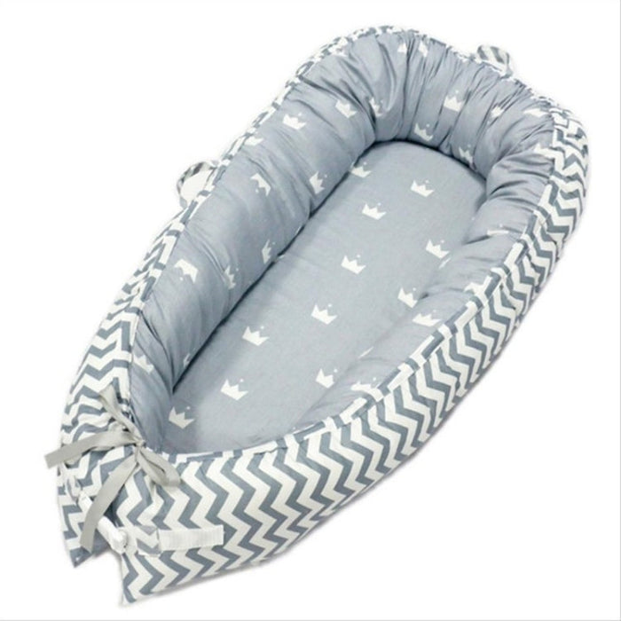 Gray baby nest crib with zigzag border and star print inner cushion