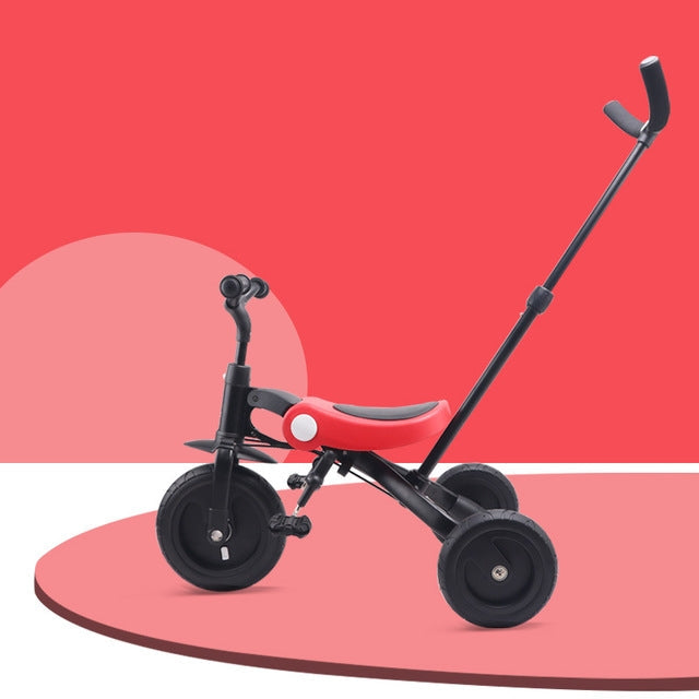 Light pink and black baby tricycle with three wheels and padded seat