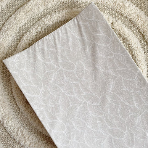 Wedge changing mat with white leaf pattern and folded edge, angled view