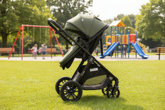 Green and black stroller on a white background
