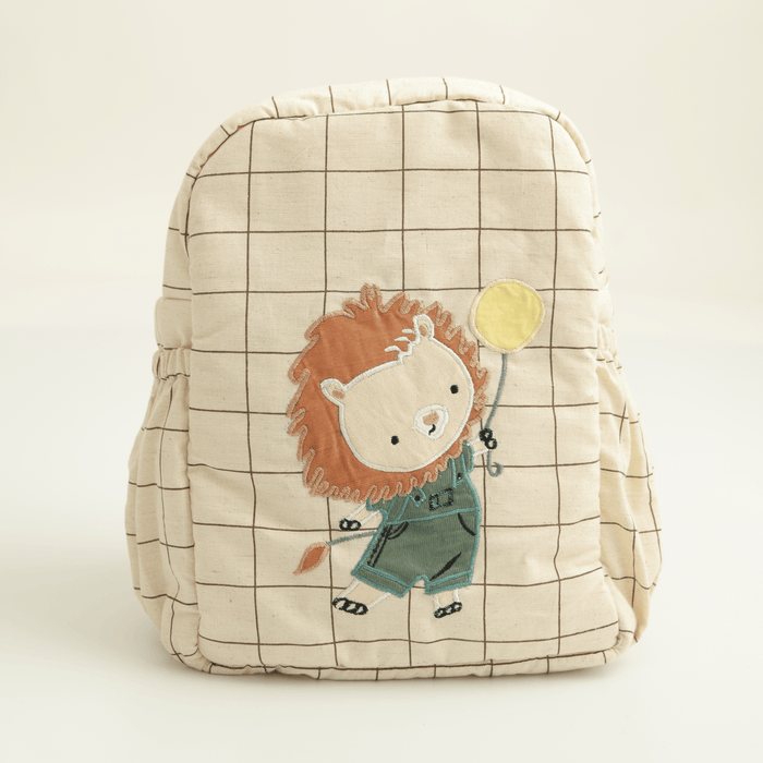Kids canvas backpack with lion patch, grid pattern, and drawstring top in cream.