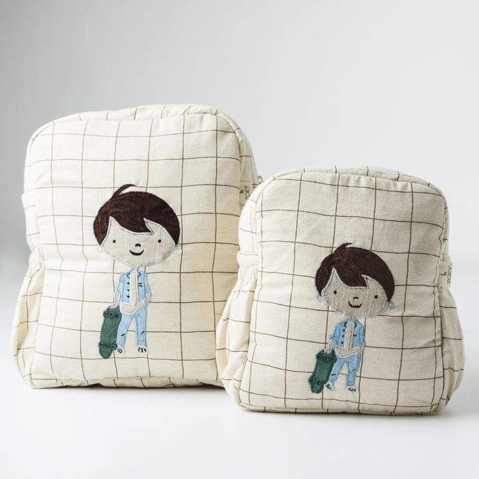 Kids backpack in cream plaid fabric with skater boy graphic on the front pocket