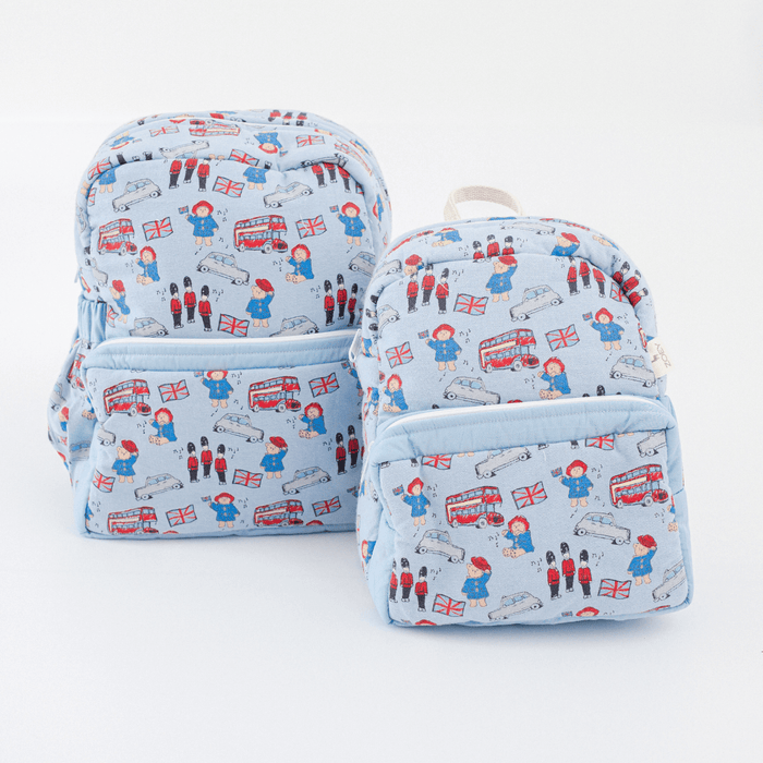 Light blue kids backpack with red UK travel pattern; shows front and side