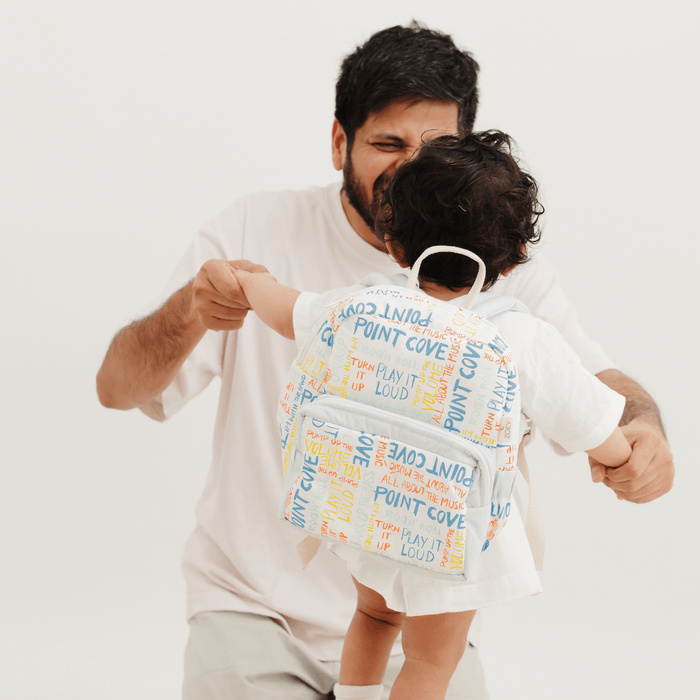 Kids backpack with light-blue colorful text scribble print, front pocket and zip closure