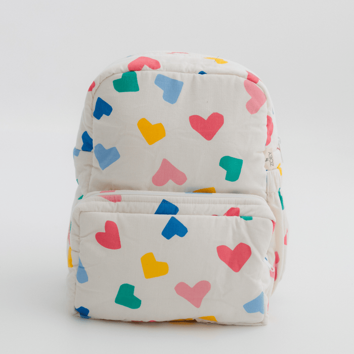 Kids backpack in white with colorful heart print and padded front pocket.