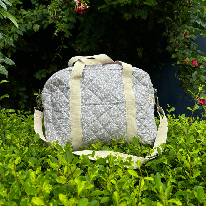 Quilted grey cotton nappy bag with light beige handles and side zippers