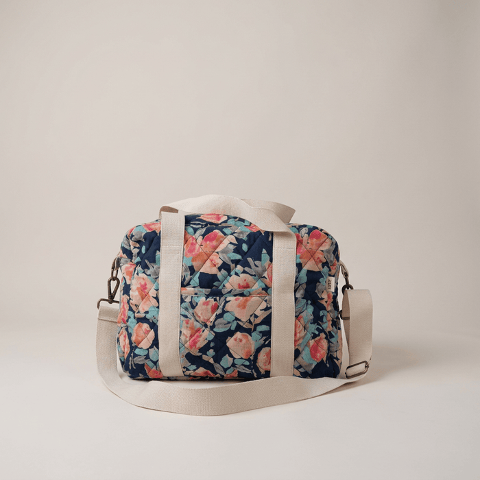 Quilted cotton nappy bag with painted floral print, navy base, light gray straps, top handles